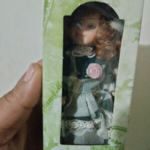 Delicate Green Porcelain Doll with Pink Rose Accent